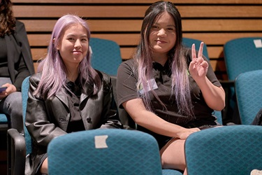 Youth Achievement Award nominee sitting in the audience next to purple-haired companion