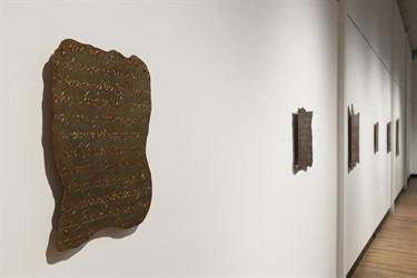 close-up of engraved copper tablet on gallery wall