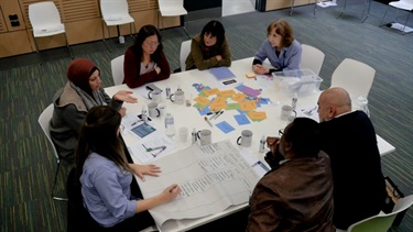 Group of people participating in a group activity around at table at the Fairfield Conversations summit