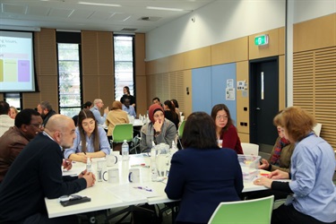 Group participants listening intently as a member of their group shares her views on a topic during a Fairfield Conversations summit group activity