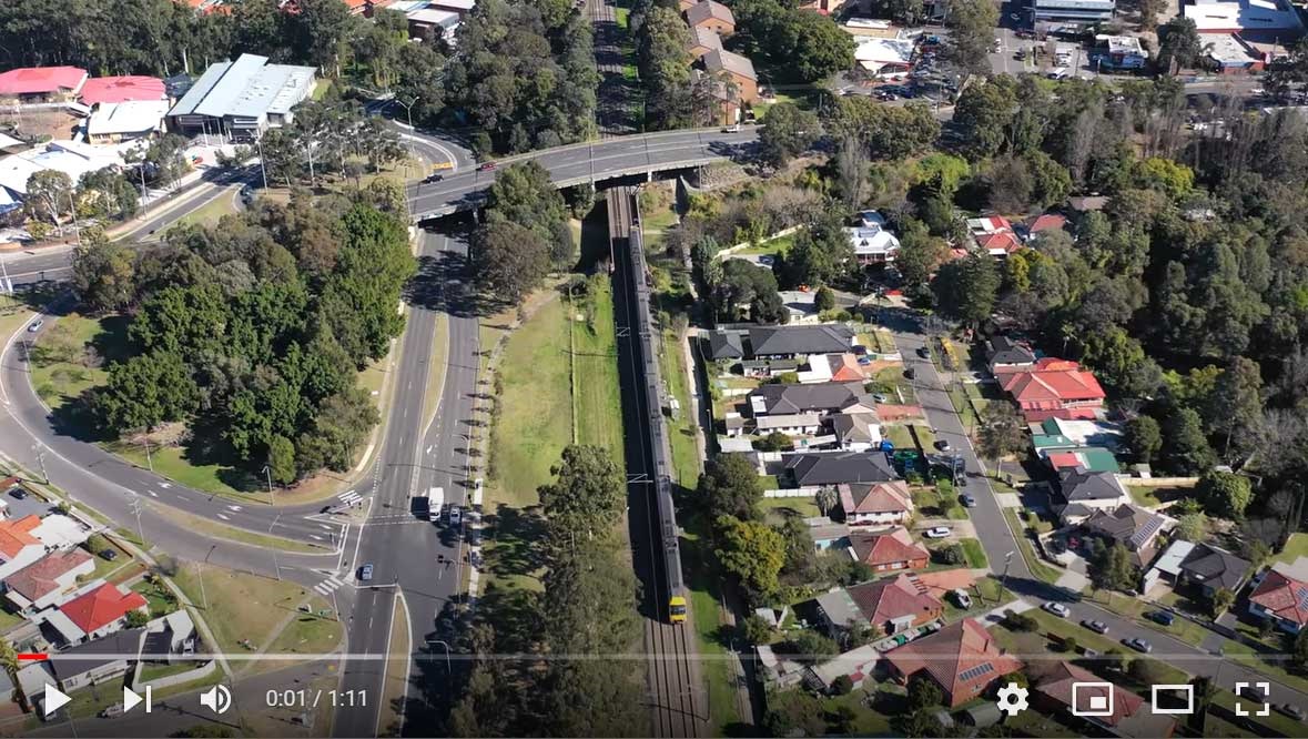 Screenshot of YouTube video with birds eye view of streets, homes and train line