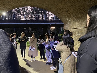 Group of women standing in circle having a group discussion in a tunnel