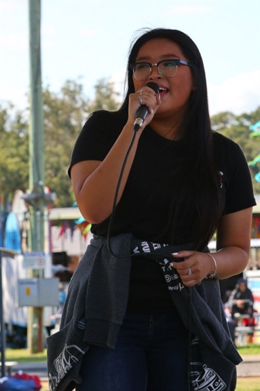 Young woman singing into a microphone