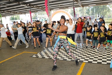 Young woman instructing dance moves to children