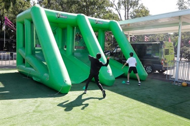 Young boys throwing balls at inflatable ball toss game