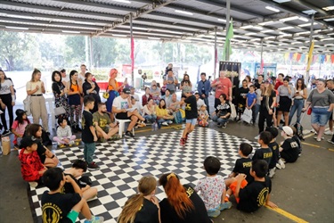 Group of young children watching young boy performing on dance floor