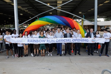 Fairfield Youth Advisory and Council Members holding Official Opening sign under Rainbow Run Entrance