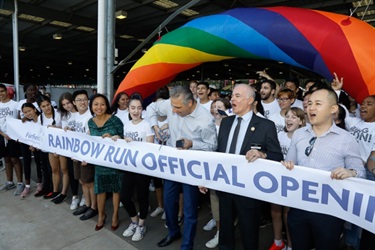 Mayor Frank Carbone cutting the Rainbow Run Official Opening Ribbon with scissors