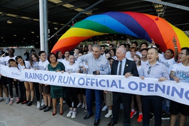 Mayor Frank Carbone cutting Rainbow Run Official Opening Ribbon with scissors