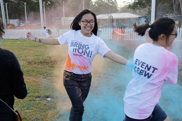 Two young girls playing in orange and blue colour powder