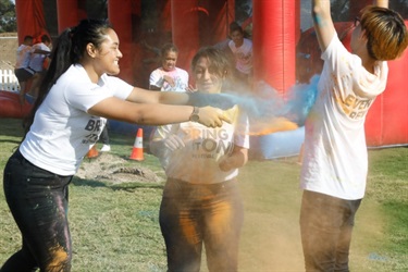 Young festival-goers getting blue colour powder thrown at them