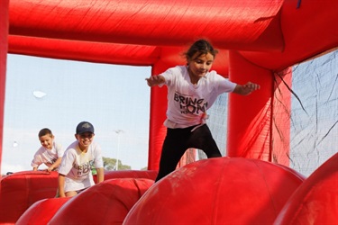 Young girl going through jumping castle obstacle