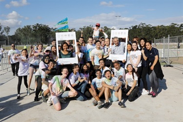 Young people posing with Council members holding Instagram frame props