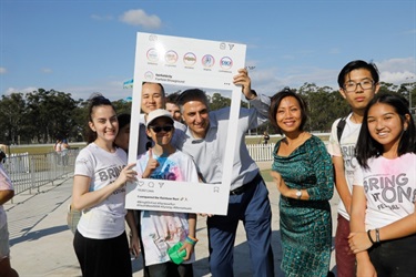 Young people and Council members posing and holding Instagram frame prop