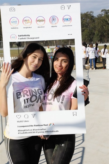 Two young girls posing with Instagram frame prop
