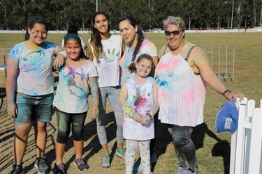 Families covered in colourful colour powder smiling and posing