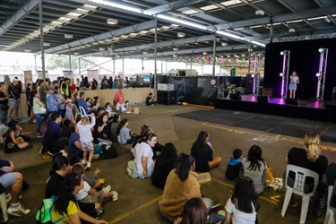 Festival go-ers watching young singer perform on stage