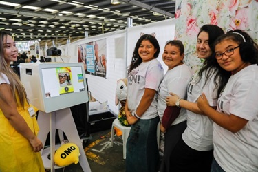 Young girls smiling and posing in front of photobooth