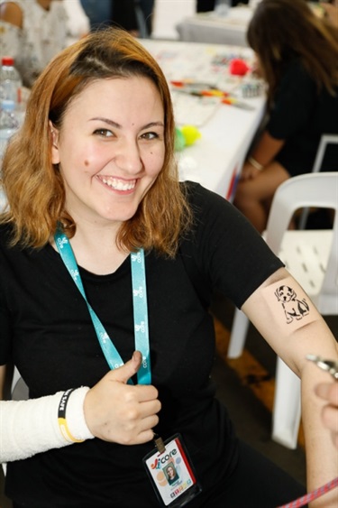 Young woman posing and showing off her air brush tattoo of a puppy