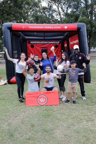 Young people posing in front of inflatable soccer goals