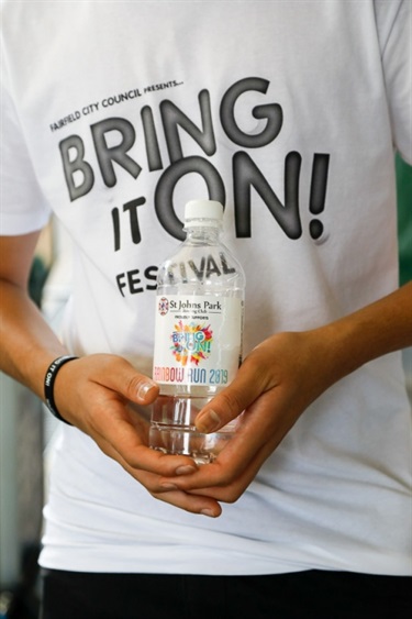 Festival go-er wearing and holding Bring It On! Festival merchandise