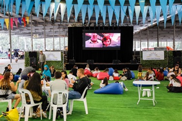 Families sitting on colourful bean bags and watching a movie