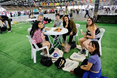 Young friends sitting around a table eating ice cream