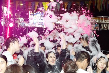 Foam coming down on young people on the dance floor
