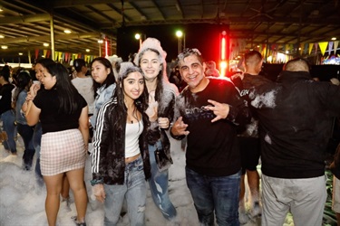 Group of young friends smiling and posing while covered in foam