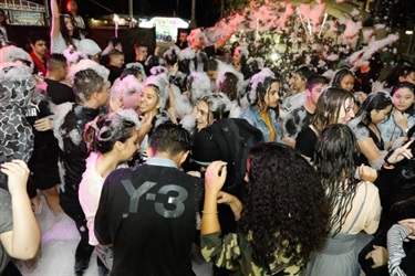 Young people covered in foam dancing on the dance floor