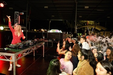 DJ Tiger Lily performing for crowd of young people covered in foam on the dance floor
