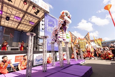 Purple Lion dancers on stilts