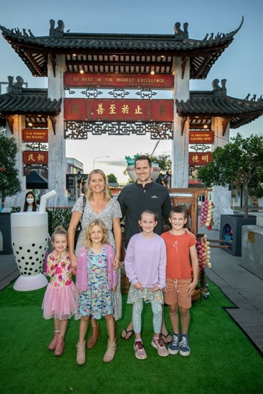 A family standing in front of Pai Lau Gate and a giant bubble tea