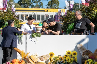 MC Andy Nguyen with people tasting Fast Ed's dish at the cooking stage