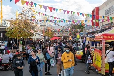 Spencer Street in Fairfield bustling with people, colourful flags and food vendors.
