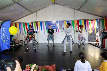 Group of young adults wearing street wear performing dance on stage