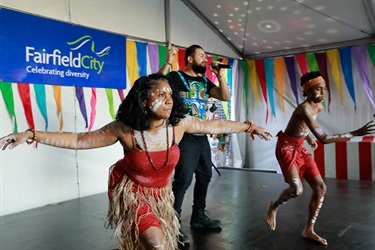 A pair of Aboriginal dancers in traditional clothing performing dance on stage