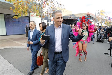 Mayor Frank Carbone smiling and walking with Councillors and Brazilian dancers