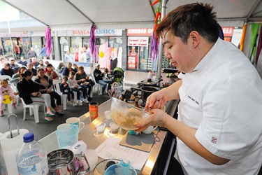 Master Chef contestant Bryan Zhu stirring batter in front of a crowd