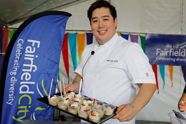 Master Chef contestant Bryan Zhu smiling and posing with tray of desserts