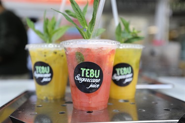 Three yellow and pink sugar cane juice drinks decorated with mint leaves