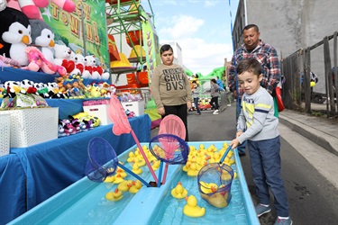 Young boy playing duck pond carnival game