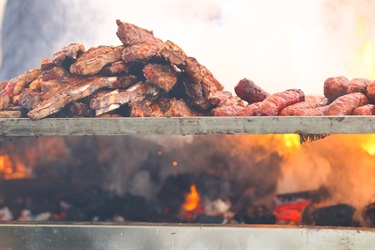 Close up of assorted meats cooking on the barbecue