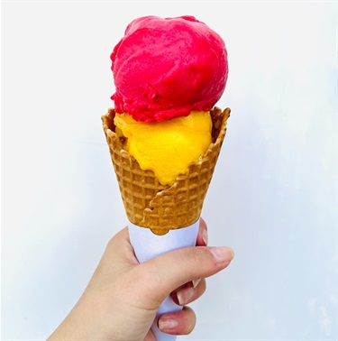 Hand holding a cone with two scoops of sorbet at Bar Coco