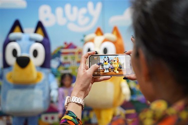 Woman taking a photo of Bluey and Bingo at meet and greet session at Fairfield Spring Fest 2022