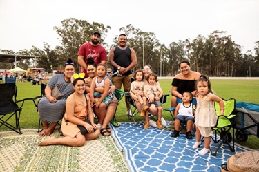 A family sitting on picnic rug