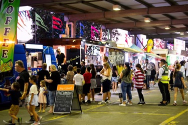 A variety of food stalls with people lining up