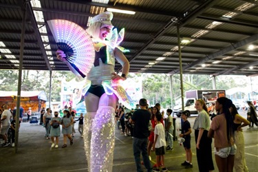 LED stilt walker holding a fan