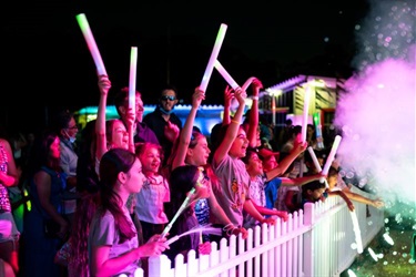 A group of people holding LED wands