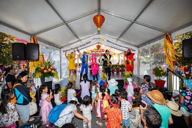 Crowd of young children watching a performance of people wearing colourful pirate costumes